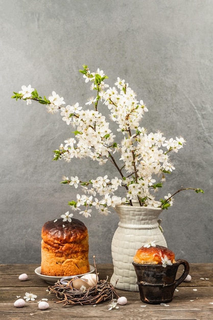 Pastel tradicional de Pascua en un estilo rústico Vintage olla para hornear ramas de ciruelo de cerezo en flor Fondo de madera