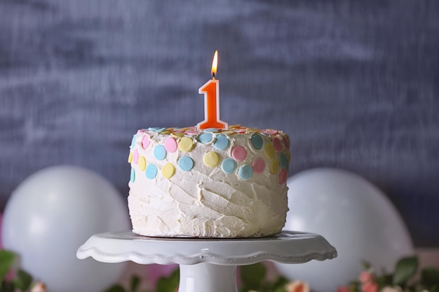 Pastel con vela para el primer cumpleaños en el puesto de postres
