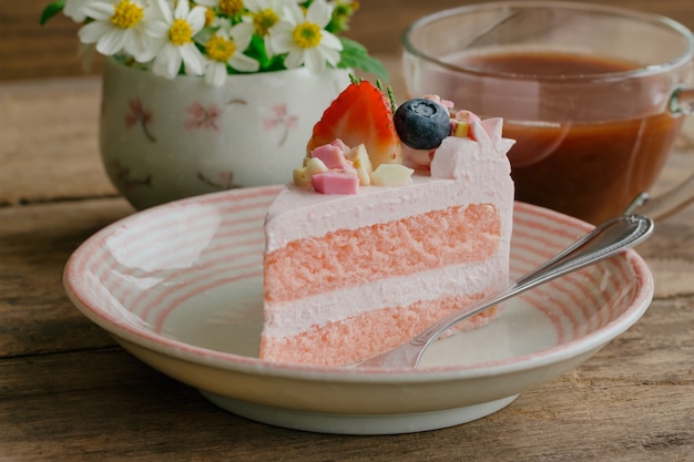 Pastel de yogur blanco y fresa de chocolate decorado con frutas frescas y trozos de chocolate.