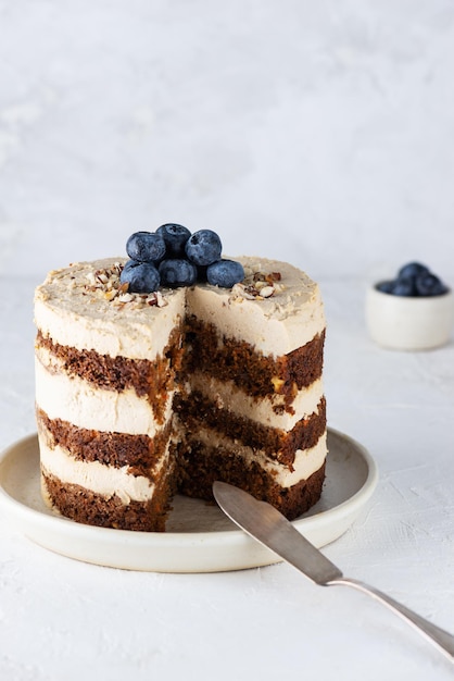 Pastel de zanahoria con crema de nueces y pasas en un plato Azúcar gluten sin lactosa vegano