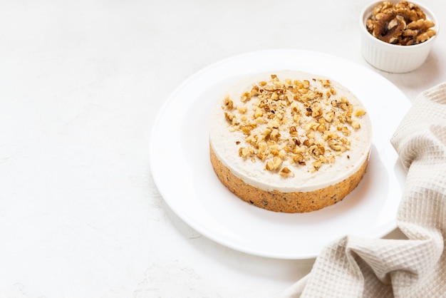 Pastel de zanahoria con nueces en una placa blanca.