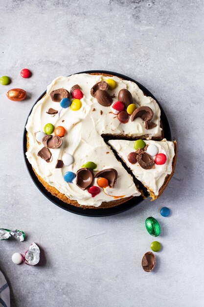 Pastel de zanahoria de Pascua en rodajas decorado con dulces y huevos de Pascua de chocolate