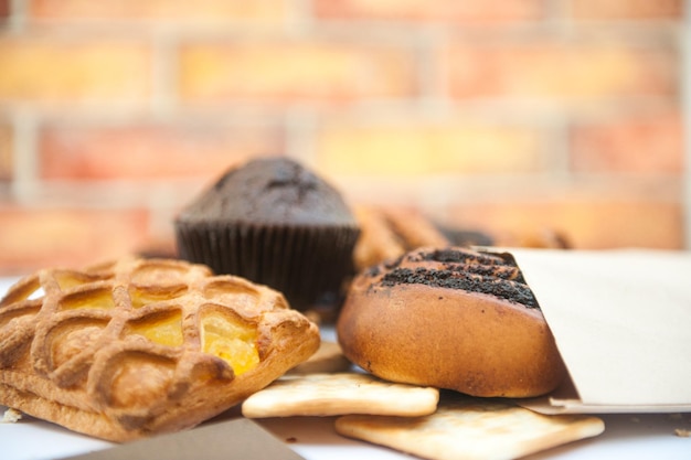 Pastelaria brilhante contra a pastelaria de pano de fundo da parede de tijolo no café ao ar livre