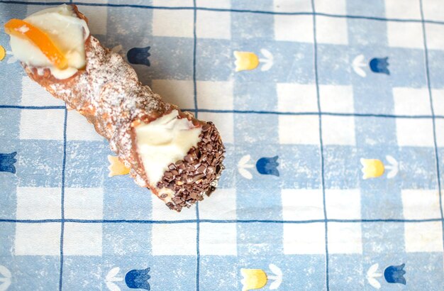 Pastelaria Cannolo acabada de fazer em fundo de mesa azul