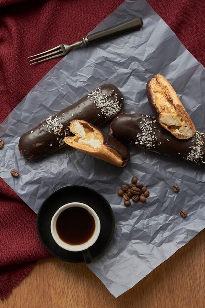 Pastelaria cheia de creme, doces franceses tradicionais com chocolate e xícara de café expresso.