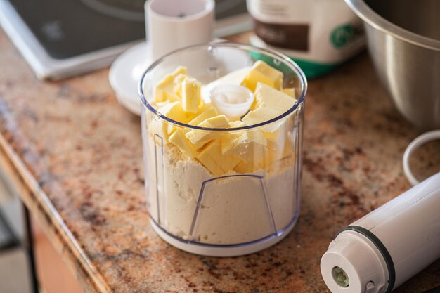 Pastelaria de massa escamosa na fabricação de farinha e manteiga em um copo de liquidificador Utensílios de cozinha conceito de estilo doméstico