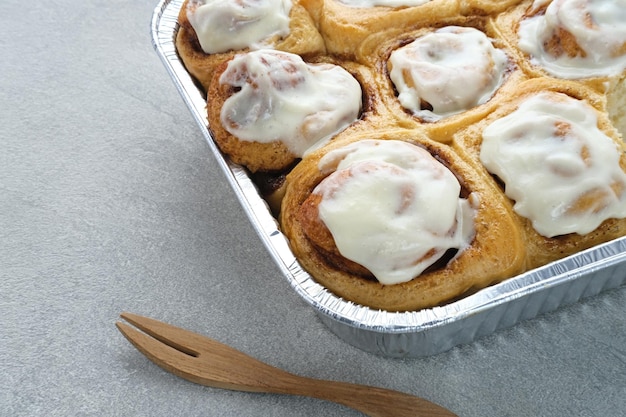 Pastelaria de rolos de canela fresca com molho de creme de baunilha. Fechar-se.