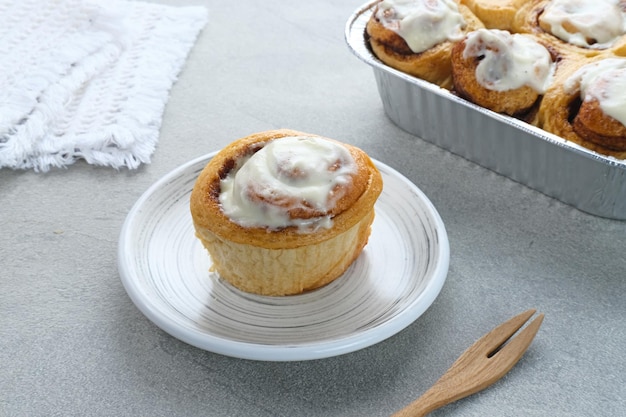 Pastelaria de rolos de canela fresca com molho de creme de baunilha. Fechar-se.