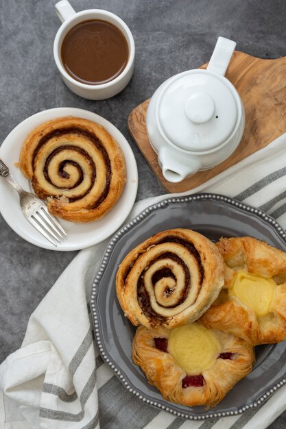 Pastelaria dinamarquesa com uma xícara de café no café da manhã. Pão de rools de canela.