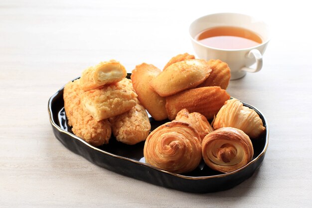 Pastelaria francesa variada com espaço de cópia na mesa de mármore branco para texto ou receita e uma xícara de chá