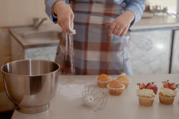 Una pastelera prepara masa rociando harina mostrando horneado casero