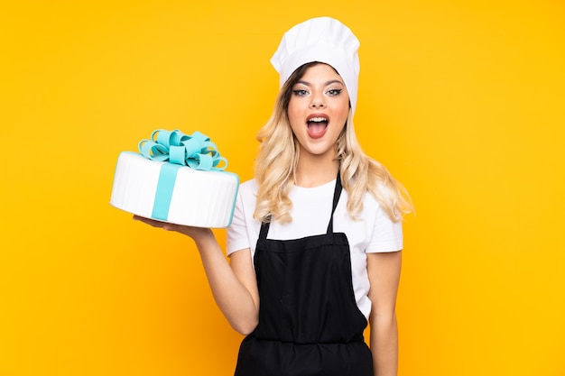 Pastelería de chica adolescente sosteniendo un gran pastel