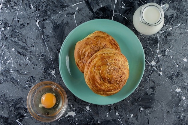 Pastelería nacional de Azerbaiyán con huevo de gallina crudo y una jarra de vidrio con leche fresca.