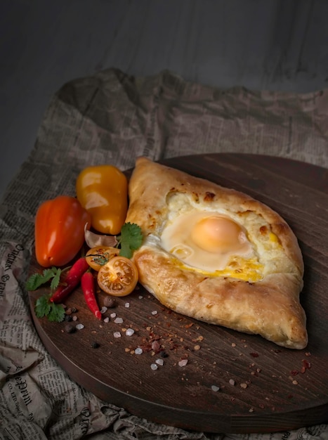 Pastelería nacional georgiana Adjarian khachapuri, pastel caliente al horno con yema de huevo sobre fondo gris