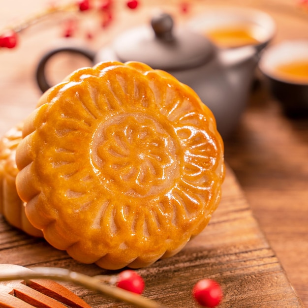 Foto pastelería tradicional china mooncake mooncake con tazas de té en una bandeja de bambú sobre fondo de madera para el festival de medio otoño cerca