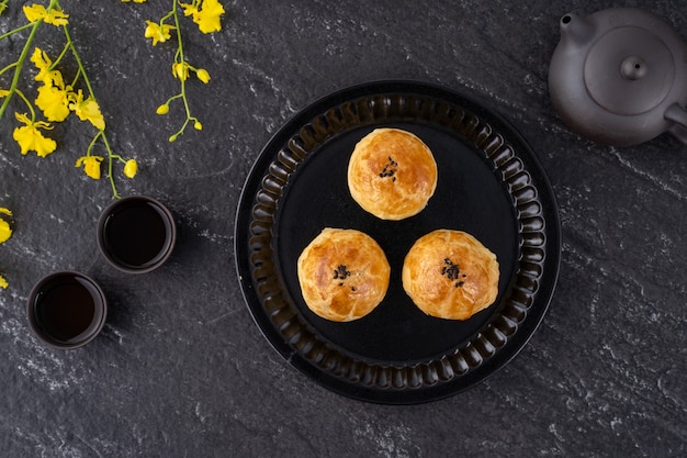 Pastelería de yema de pastel de luna, pastel de luna para las vacaciones del Festival del Medio Otoño, concepto de diseño de vista superior en mesa de madera oscura con espacio de copia, endecha plana, fotografía cenital