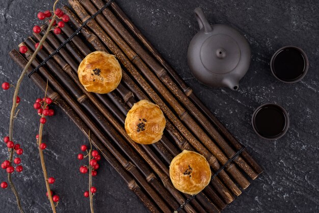 Pastelería de yema de pastel de luna, pastel de luna para las vacaciones del Festival del Medio Otoño, concepto de diseño de vista superior en mesa de madera oscura con espacio de copia, endecha plana, fotografía cenital