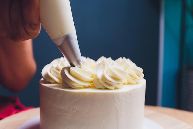 Pastelero decorado con bayas un pastel de galletas con crema blanca Pastel se encuentra sobre una mesa de madera El concepto de pasteles caseros para cocinar pasteles