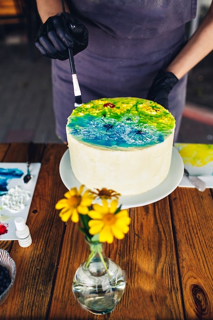 Pastelero decorar pastel con crema de colores. pastel hecho a mano con patrón.