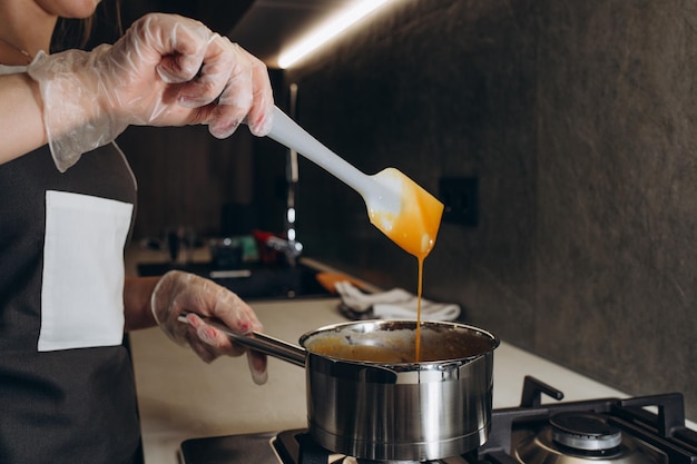 Pastelero femenino prepara crema en la cocina