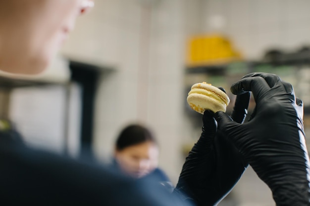 Un pastelero hace macarrones en una pastelería