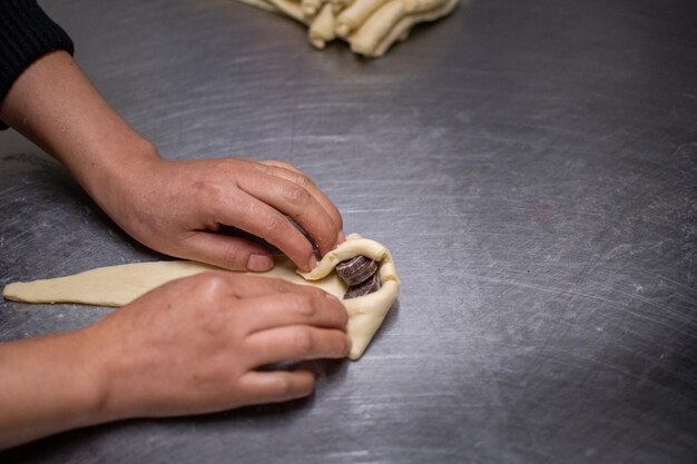 Pastelero manos haciendo croissants de chocolate