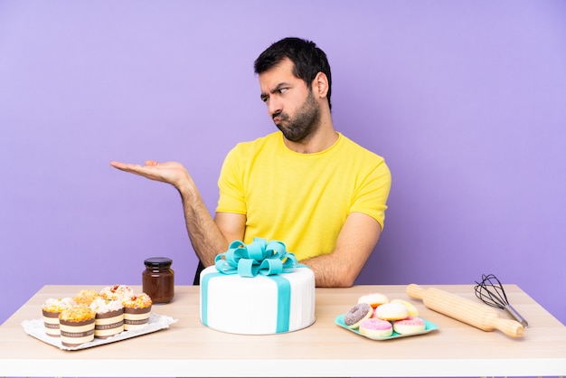 Pastelero con mesa llena de dulces