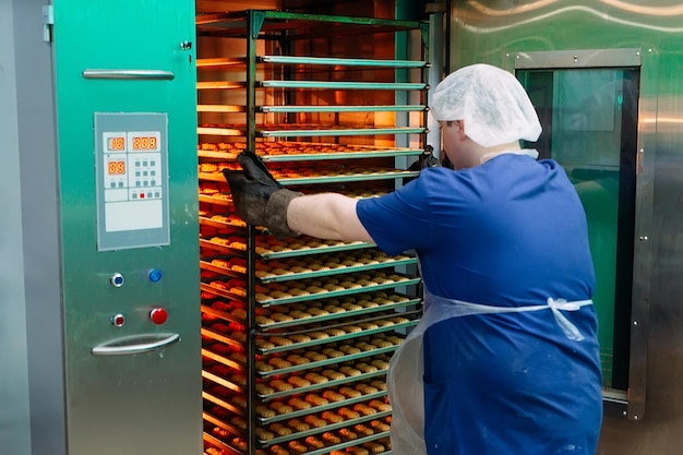 El pastelero saca del horno las galletas de mantequilla preparadas.