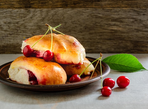 Pasteles caseros con cerezas en un plato de arcilla Horneado casero