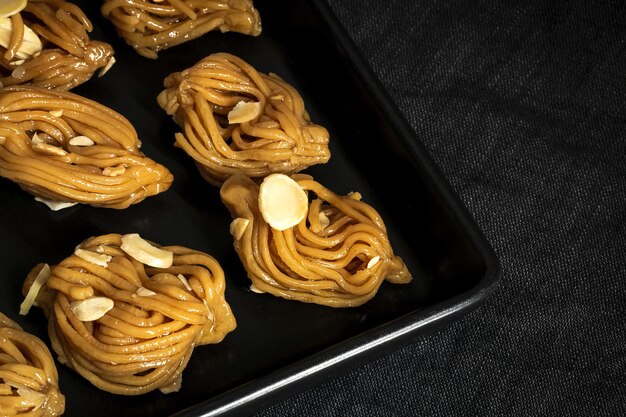 Pasteles caseros de chebakias dulces típicos marroquíes con miel para el Ramadán y ayuda en la comida halal de fondo oscuro