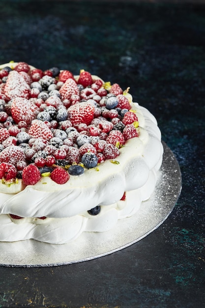 Pasteles de corona de pavlova de merengue con crema batida y bayas frescas