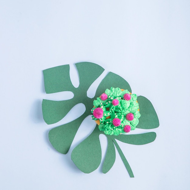 Pasteles creativamente decorados con suculentas sobre un fondo azul con hojas tropicales de papel