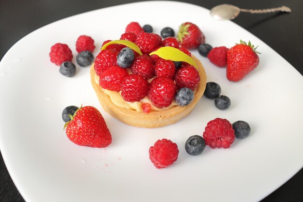 pasteles de crema con frambuesas y arándanos un conjunto de diferentes glaseados en chocolate negro con custa