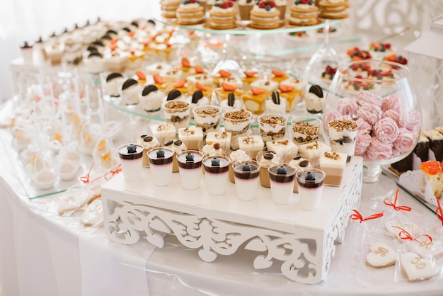 Pasteles dulces de postre y magdalenas y gelatinas en la barra de chocolate en la celebración