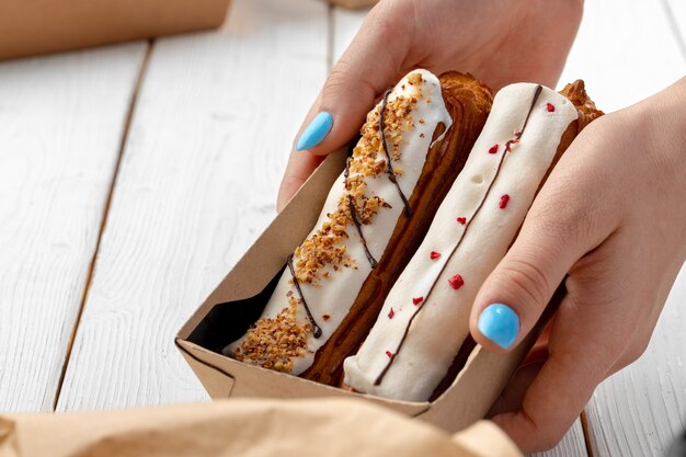 Pasteles de eclair frescos en una caja de cartón