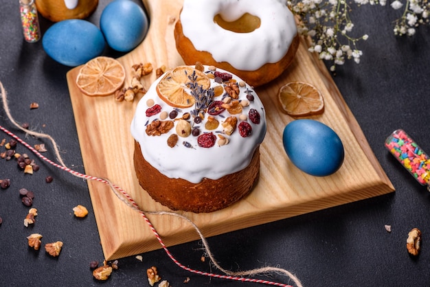 Pasteles festivos con glaseado blanco, nueces y pasas con huevos de Pascua en la mesa festiva