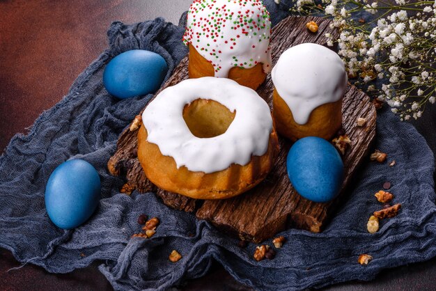 Pasteles festivos con glaseado blanco, nueces y pasas con huevos de Pascua en la mesa festiva