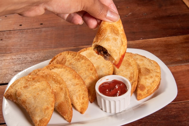 Foto pasteles fritos pastel frito brasileiro sobre mesa de madera pastel de carne