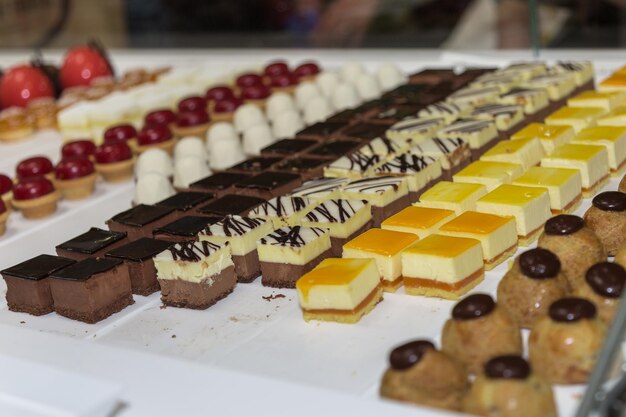 Foto pasteles y galletas de colores dentro de una vitrina en una pastelería