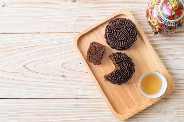 Pasteles de luna chinos con sabor a chocolate negro sobre placa de madera