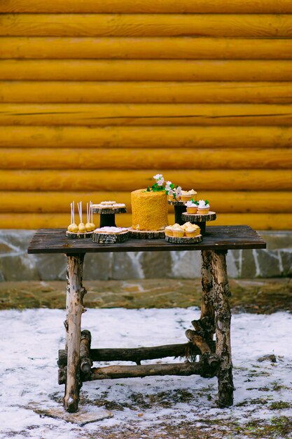 pasteles en una mesa de madera para una boda candy bar