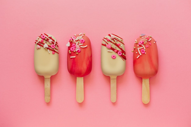 Pasteles de paleta rosa sobre un fondo rosa