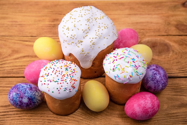 Pasteles de Pascua y huevos de Pascua de colores sobre un fondo de madera. Fiesta religiosa de Pascua brillante.