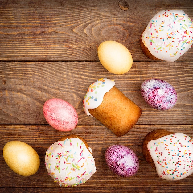 Pasteles de Pascua y huevos de Pascua de colores sobre una superficie de madera. Fiesta religiosa de Pascua brillante.