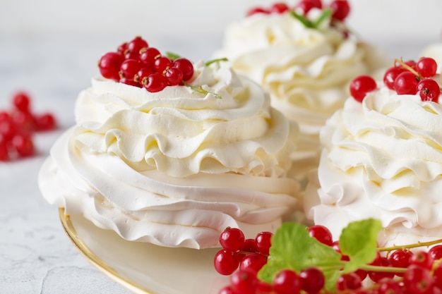 Pasteles de Pavlova con crema y bayas frescas de verano