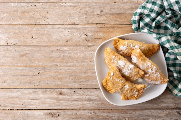 Pasteles rellenos dulces españoles llenos de cabello de ángel en la mesa de madera.