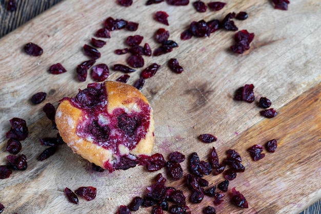 Foto pasteles de trigo con relleno de fresa cereza roja en un tablero arándanos secos secos en almíbar dulce están tirados alrededor de la cocción