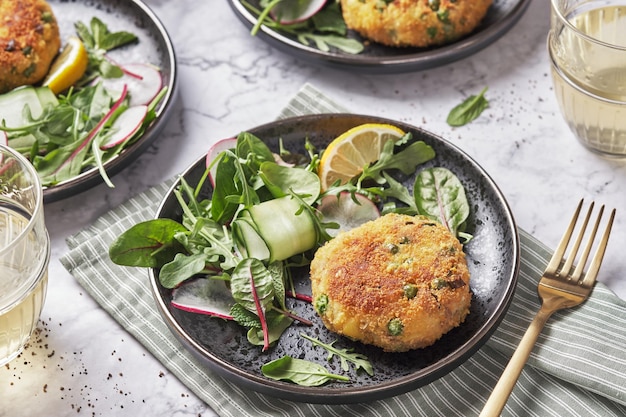 Pastelitos de caballa servidos con ensalada de rúcula, espinacas y berros