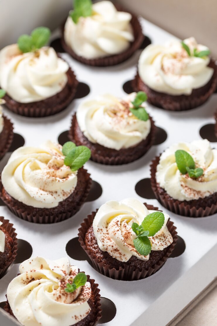 Pastelitos de chocolate con crema de queso y hojas de menta en caja de entrega
