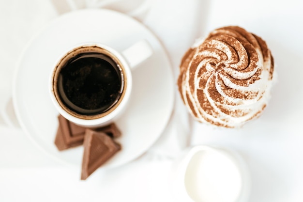 Pastelitos de chocolate oscuro y chocolate con cacao con una taza de café negro caliente en una servilleta verde Espacio para texto